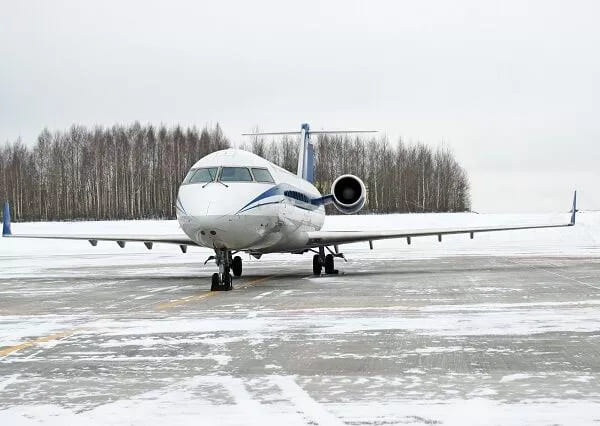 A private jet on tarmac in snowy weather