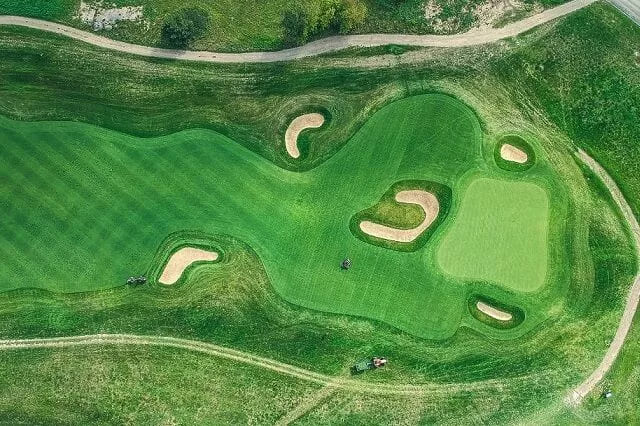 Aerial view of a pristine golf course, where golfers with private jets enjoy exclusive access and unparalleled leisure experiences