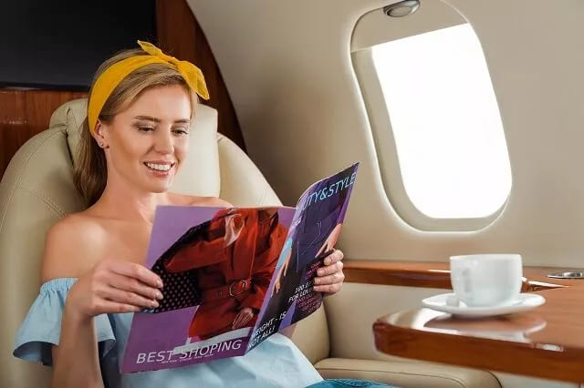 Hot girl reading a magazine inside private jet